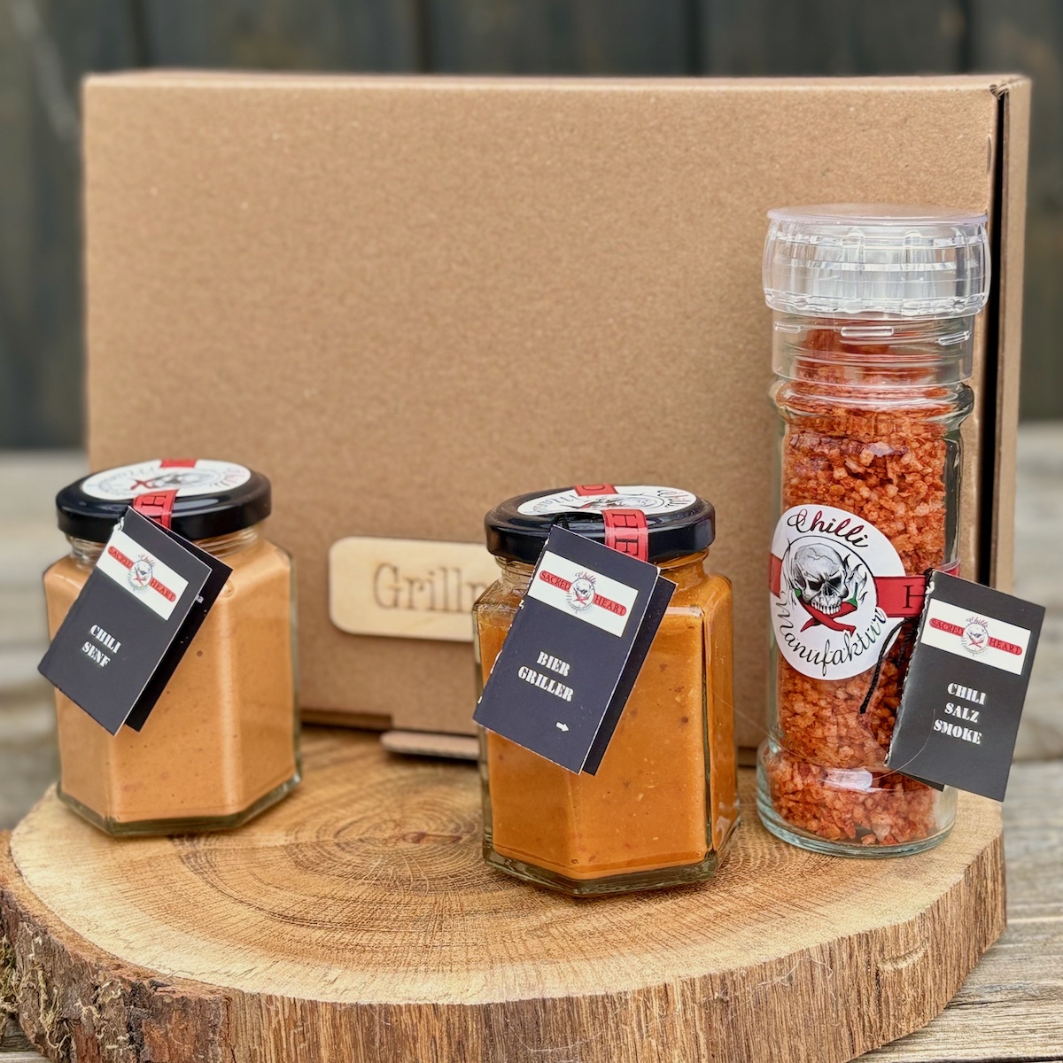 Grillbox Geschenkkarton mit der Beschriftung Grillmeister und dem Inhalt Chili Senf, Bier Griller und Chilsailz smoke