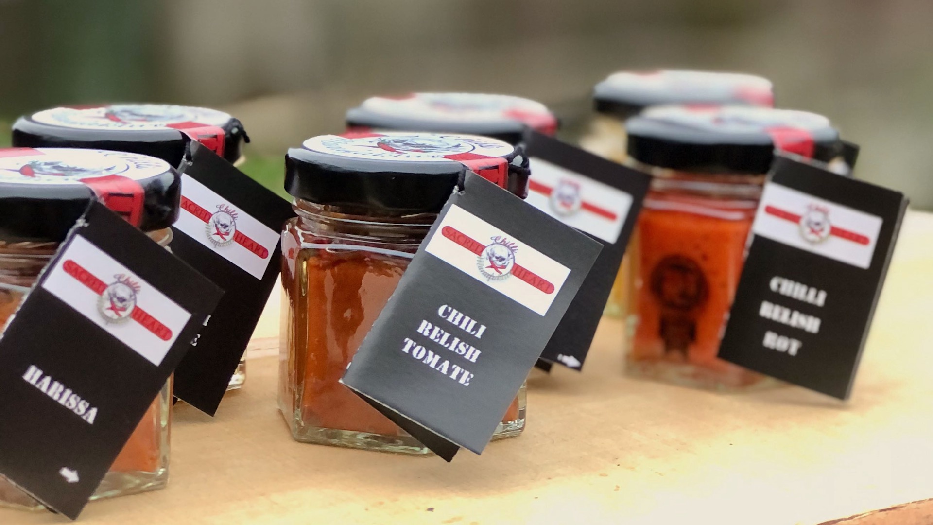 Chili Paste kaufen Unterschiedliche Chili Paste im Glas auf Holzuntergrund zum kaufen