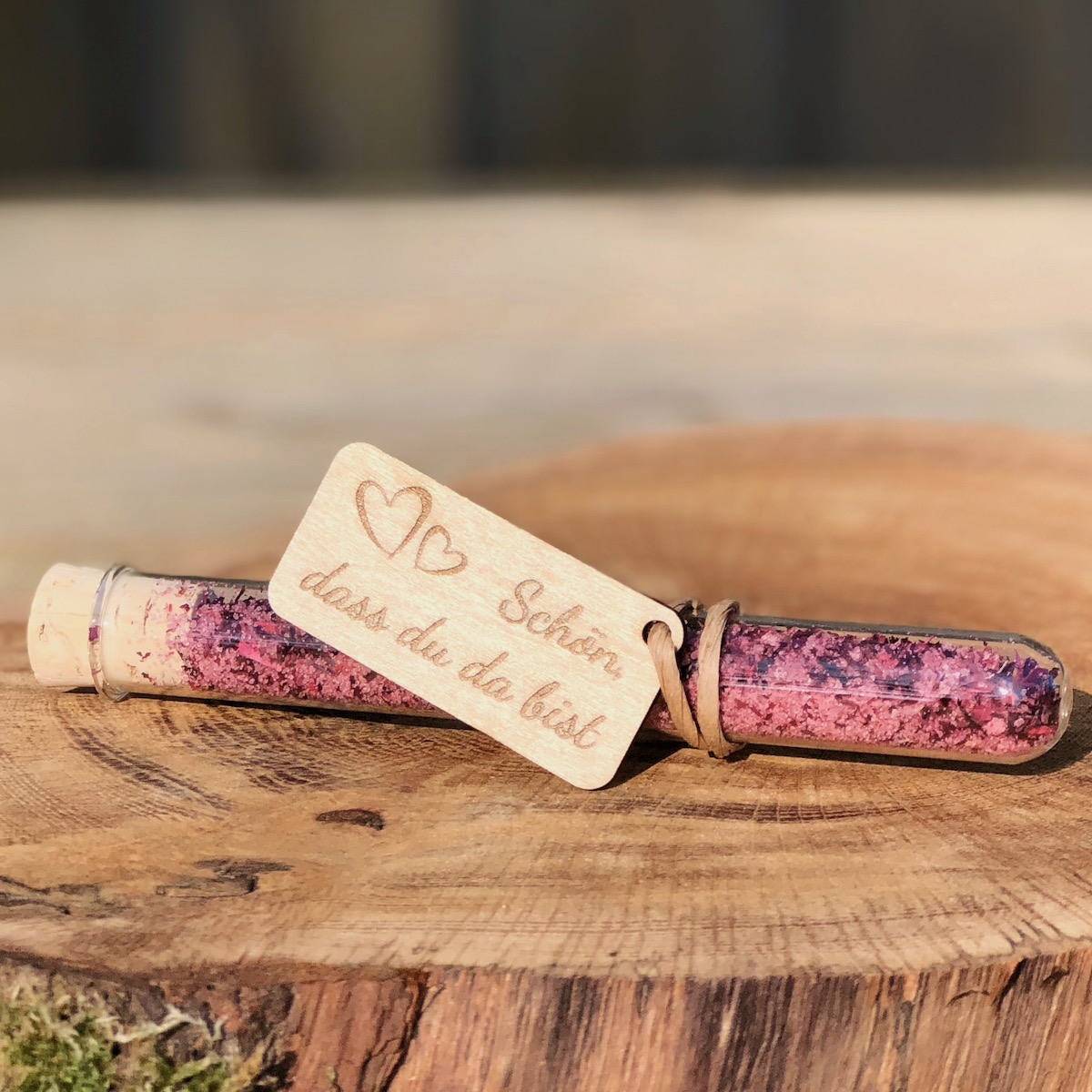 Gastgeschenk Stullengewürz Holzanhänger mit Herz Schön dass du da bist Gastgeschenk Stullengewürz im Reagenzglas mit Anhänger Schreibschrit Schön dass du da bist auf einer Holzscheibe liegend