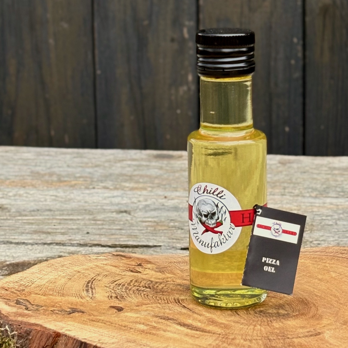 Flasche mit Pizzaöl auf einer Holzscheibe stehendzum Kaufen