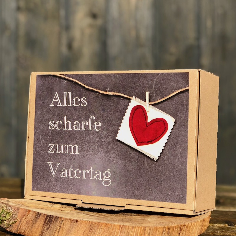 Geschenk zum Vatertag kaufen Geschenk zum Vatertag Box mit unterschiedlichen Chiliprodukten mit der Aufschrift alles scharfe zum Vatertag und roten Herz