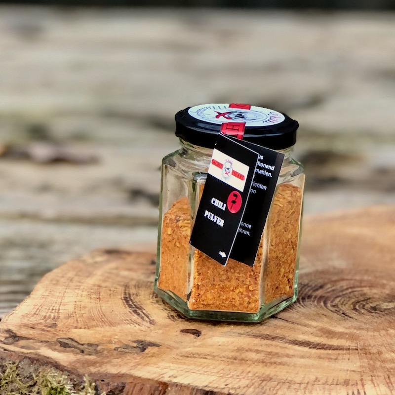 Chilipulver Schärfegrad 7 kaufen Chilipulver Schärfegrad 7 im Glas von der Chilli Manufaktur auf einem Tisch stehend zum kaaufen