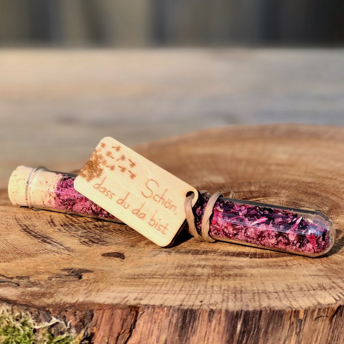 Gastgeschenk Stullengewürz Holzanhänger mit Pusteblume Schön dass du da bist Gastgeschenk Stullengewürz im Reagenzglas mit Anhänger Pusteblume Schön dass du da bist auf einer Holzscheibe liegend