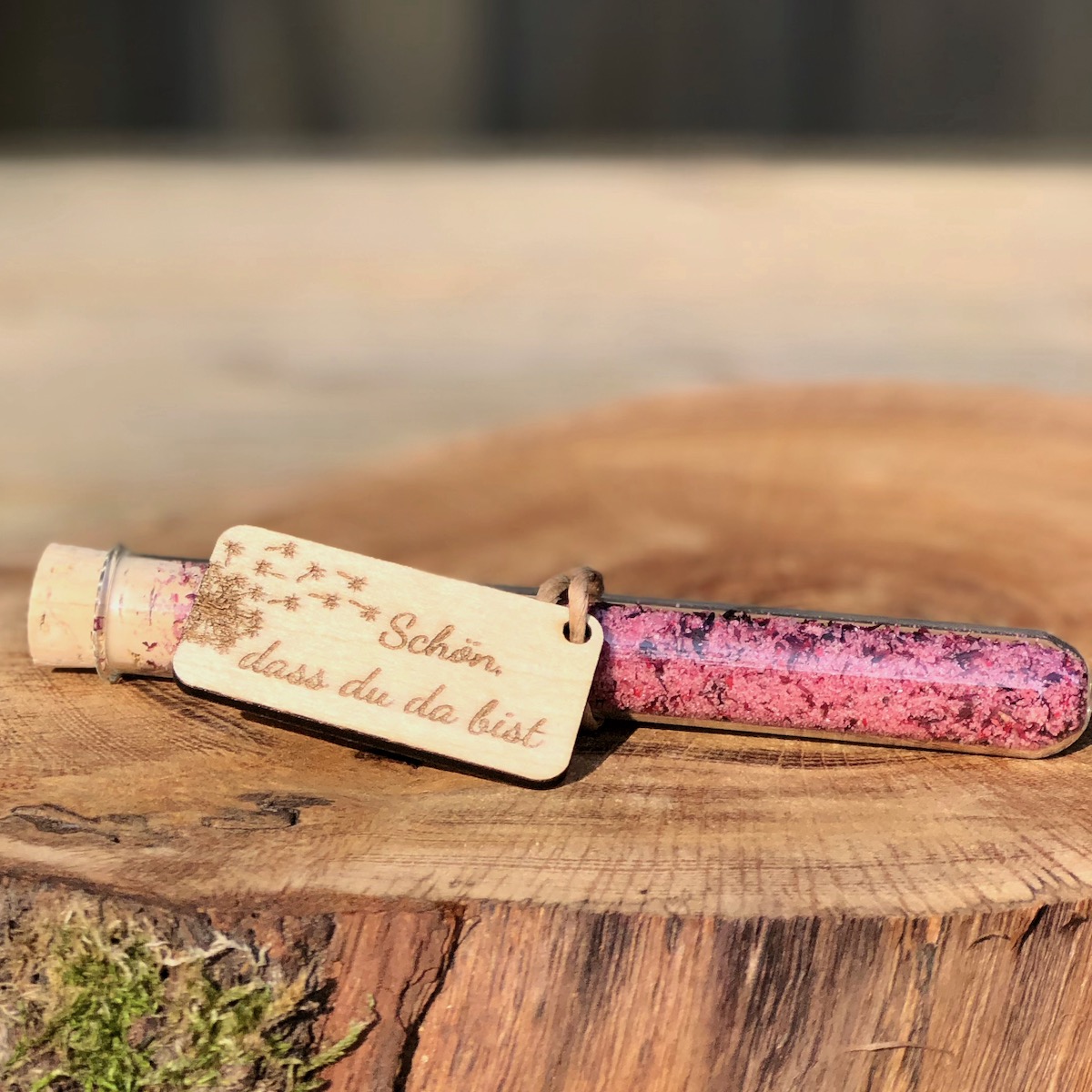 Gastgeschenk Stullengewürz Holzanhänger mit Pusteblume Schön dass du da bist Schreibschrift Gastgeschenk Stullengewürz im Reagenzglas mit Anhänger Pusteblume Schön dass du da bist auf einer Holzanhäner mit Pusteblume liegend Schreibschrift