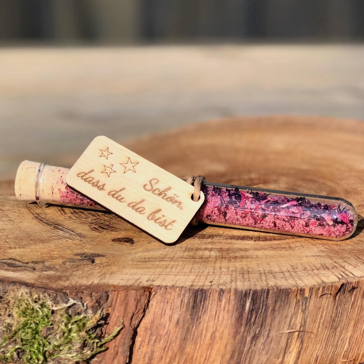 Gastgeschenk Stullengewürz Holzanhänger mit Stern Schön dass du da bist Gastgeschenk Stullengewürz im Reagenzglas mit Anhänger Pusteblume Schön dass du da bist auf einer Holzanhäner mit Stern liegend Schreibschrift