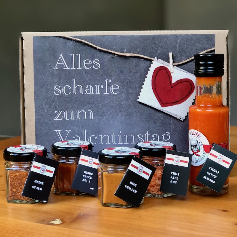 Das Bild zeigt eine Geschenkbox zum Valentinstag mit 5 Chiliprodukten als Inhalt als Geschenk für Männer