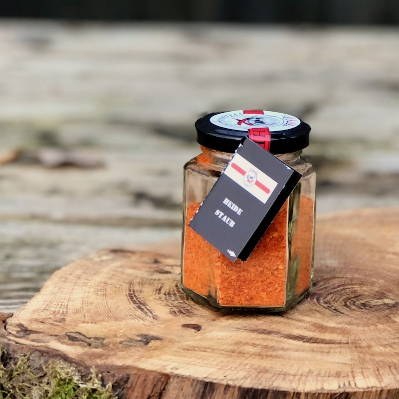 Chili Pulver Heidestaub kaufen Chili Pulver Heidestaub im Glas auf einer Holzscheibe auf einem Tisch stehend